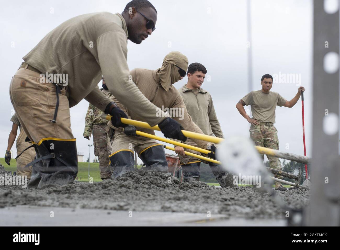 Airmen assigned to the 800th RED HORSE Group, level wet concrete as part of a construction project to expand a flightline apron June 30, 2021, at Yokota Air Base, Japan. The construction project requires Airmen assigned to the 823rd, 819th and 820th RED HORSE Squadrons to pour approximately 7,300 cubic meters of concrete and pave 650 tons of asphalt in a construction effort to increase aircraft parking capabilities at Yokota Air Base. The apron expansion is the first in an approximately four-year phased construction effort to enhance Yokota Air Base’s airlift mission capabilities. Stock Photo