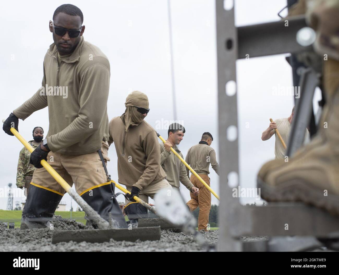 Airmen assigned to the 800th RED HORSE Group, level wet concrete as part of a construction project to expand a flightline apron June 30, 2021, at Yokota Air Base, Japan. The construction project requires Airmen assigned to the 823rd, 819th and 820th RED HORSE Squadrons to pour approximately 7,300 cubic meters of concrete and pave 650 tons of asphalt in a construction effort to increase aircraft parking capabilities at Yokota Air Base. The apron expansion is the first in an approximately four-year phased construction effort to enhance Yokota Air Base’s airlift mission capabilities. Stock Photo