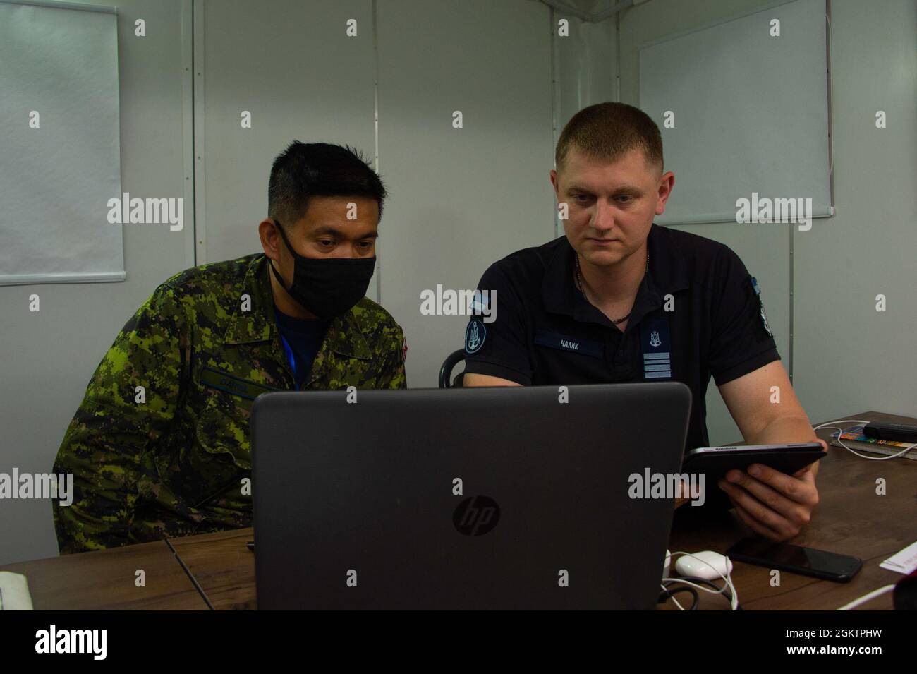 210701-F-D0094-0007 ODESA, Ukraine (July 1, 2021) Senior Public Affairs Officers for Exercise SEA BREEZE 21, Major Christopher Daniel from the Canadian Armed Forces (CAF) and Commander Chalyk Oleh from the Ukrainian Navy, conduct media monitoring and analysis in Odesa, Ukraine on July 1, 2021. Co-hosted by the United States Navy Stock Photo