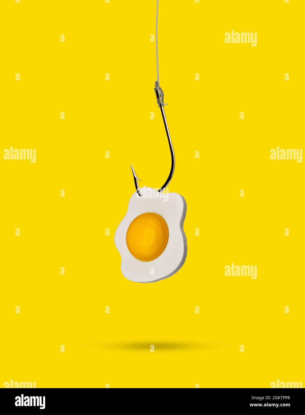 Fried egg on a fishing hook. Minimal food concept. Stock Photo