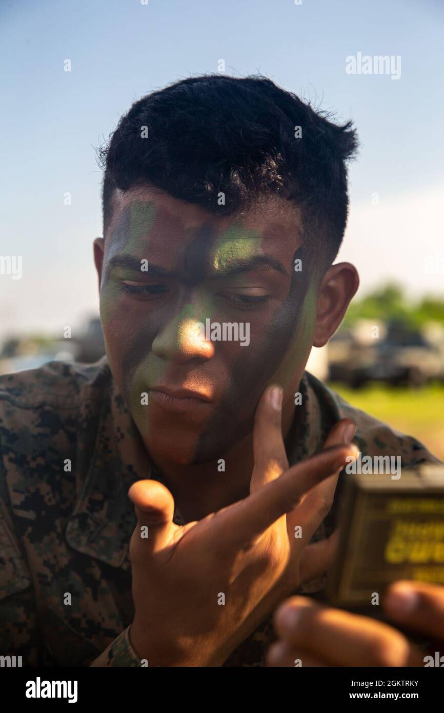U.S. Marine Corps Pfc. Erick Canas a Santa Tecla, American Samoa Island native and rifleman with Alpha Company, 1st Battalion, 6th Marine Regiment, 2d Marine Division, applies camo paint to his face in preparation for a company sized raid during Exercise Sea Breeze 21 in a nondisclosed location on July 1, 2021. Exercise Sea Breeze 21 brings together military units from over thirty nations to cultivate and strengthen relations and techniques as warfighting organizations. Stock Photo