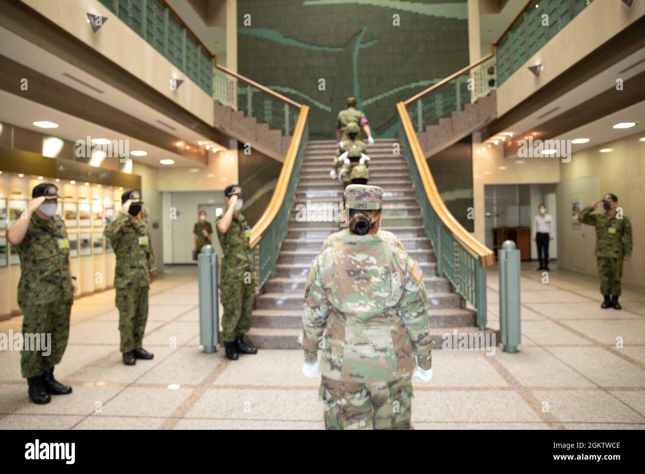 The 40th Infantry Division and Japan Ground Self-Defense Force flag details climb flights of stairs to the Middle Army Headquarters roof on Camp Itami, Japan on July 2, 2021 for the joint raising of their flags during bilateral exercise Orient Shield 21-2. Stock Photo