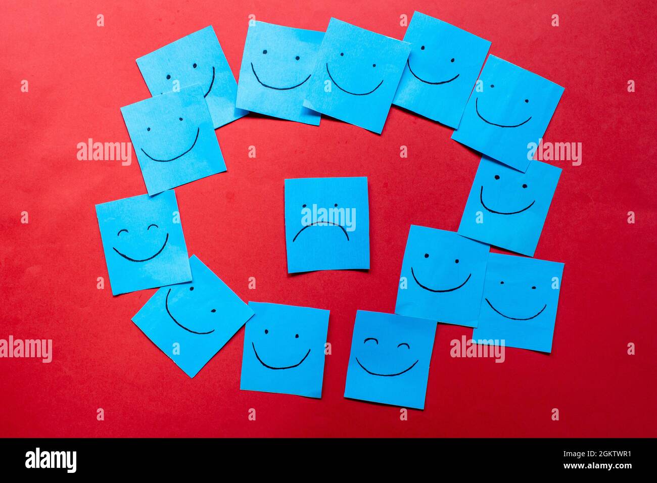 Hand drawn faces on stickers. One sad face among happy faces. Exclusion,discrimination,  difference concept. Stock Photo