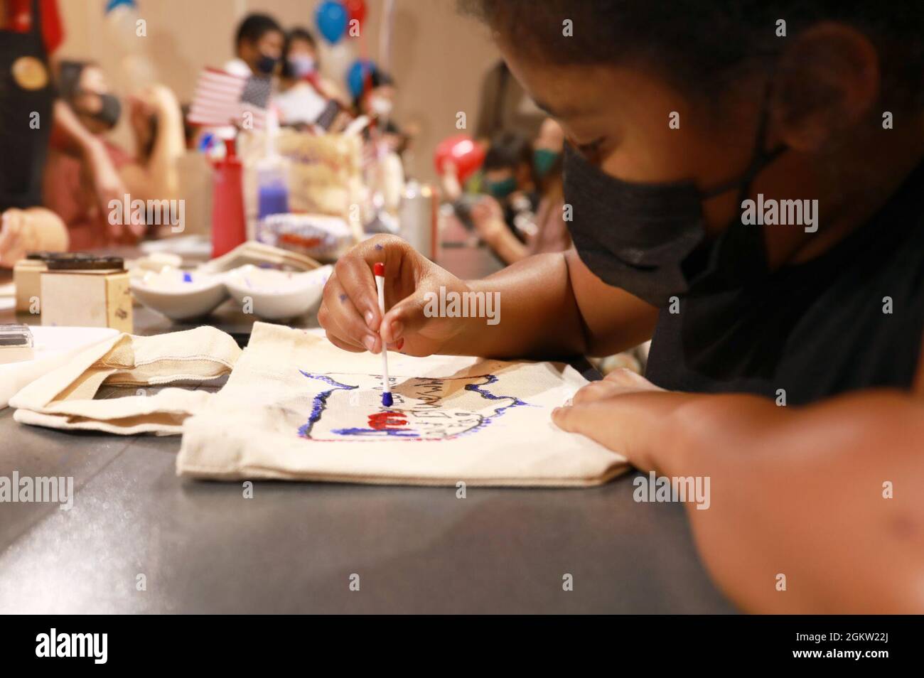 Destiny Hines, 10, decorates a reusable tote bag at the artsandcrafts
