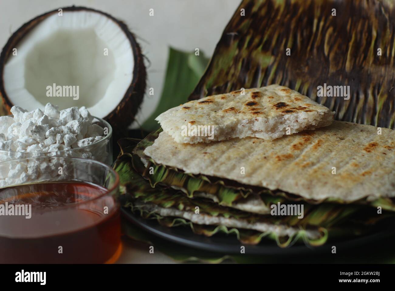 Arrowroot Ottada is a healthy wholesome snack. Made with ground arrowroot blended with coconut. Cooked on a tawa like appam wrapped with banana leaf. Stock Photo