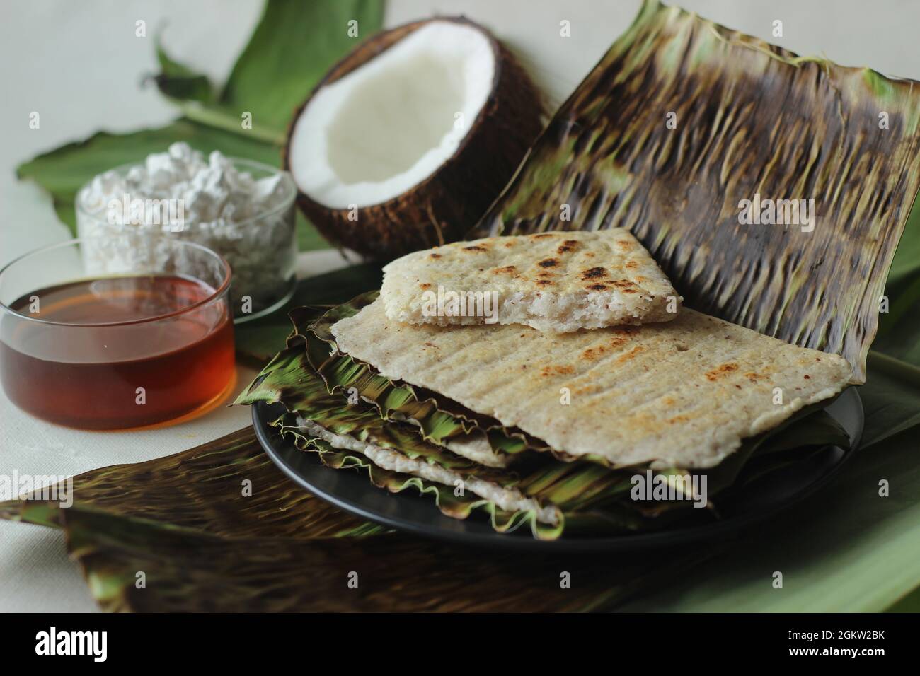 Arrowroot Ottada is a healthy wholesome snack. Made with ground arrowroot blended with coconut. Cooked on a tawa like appam wrapped with banana leaf. Stock Photo