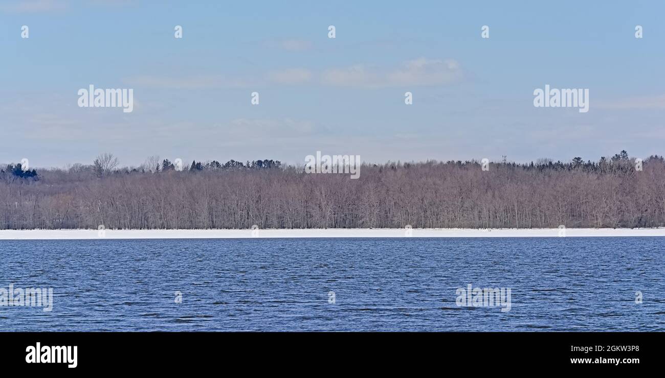 Bare winter forest and snow on the embankment of Ottawa river, Ontario, canada Stock Photo