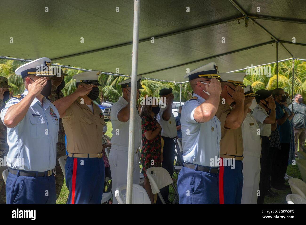 Marine Corps Base (MCB) Camp Blaz senior leaders render a salute during the playing of the national anthem during a wreath laying ceremony and memorial service at the Manenggon memorial site, July 5, 2021. Manenggon was the site of one of the concentration camps for the CHamoru people during World War II. The memorial service was among the many held across the island to commemorate the liberation of Guam during World War II in 1944. Stock Photo
