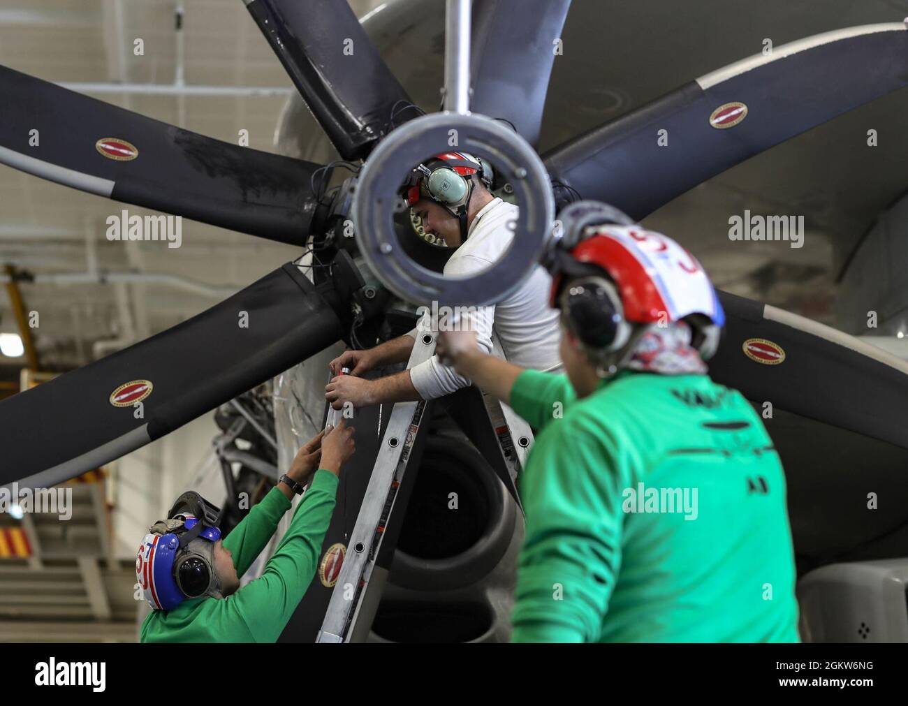 210706-N-XZ686-1097        PACIFIC OCEAN (July 6, 2021) Aviation Machinist’s Mate Airman Luis Herrera-Chacon (right), from Santa Ana, El Salvador, Aviation Machinist’s Mate Airman Jesse Barajas (left), from Perris Calif., and Aviation Machinist’s Mate 2nd Class Joshua Smith Choctaw Okla., remove the propeller variable pitch actuator from an E-2D Hawkeye assigned to the “Wallbangers” of Carrier Airborne Early Warning Squadron (VAW) 117 aboard the aircraft carrier USS Abraham Lincoln (CVN 72). Abraham Lincoln is underway conducting routine operations in the U.S. 3rd Fleet area of operations. Stock Photo