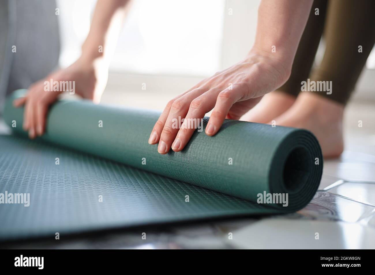 Woman rolling out yoga mat for workout at home. Yogini athlete doing  exercises in the morning. Healthy lifestyle concept Stock Photo - Alamy