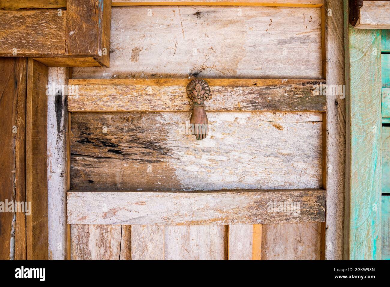 Hand shaped rusty iron knocker on retro vintage style wood door Stock Photo