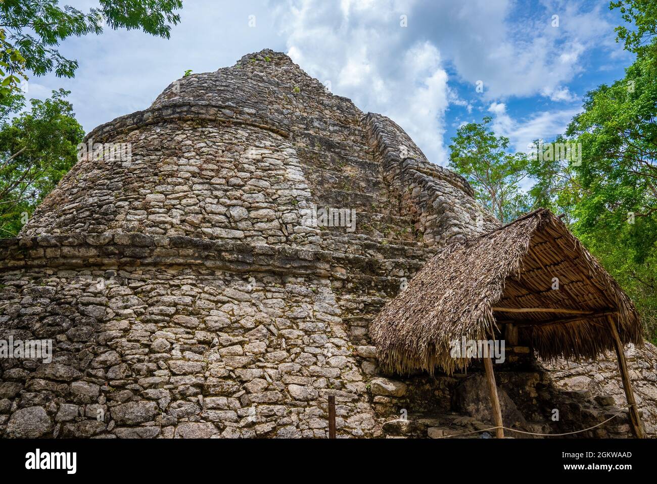 Nohoch Mul Pyramid and temple with straw roof in the Maya ruins of Coba Stock Photo