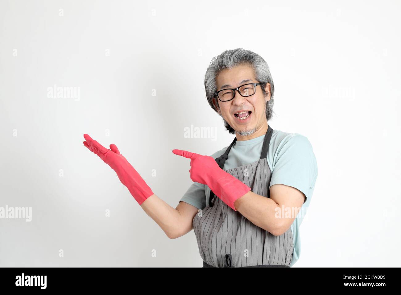 The senior Asian housekeeper standing on the white background. Stock Photo