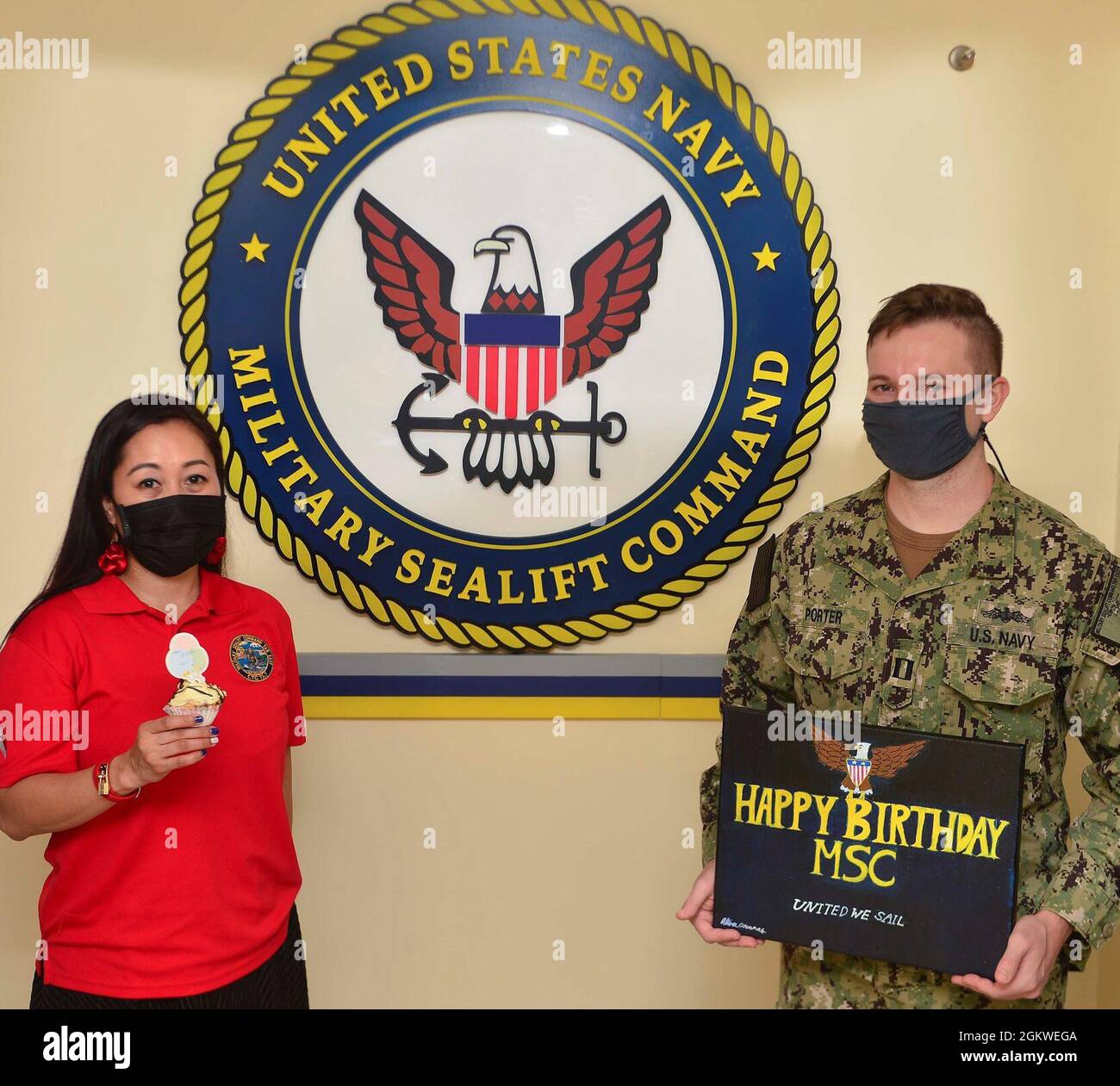 From left, Military Sealift Command Far East’s Theresa Aranas and Lt. Gerrit Porter, a reservist, recognize MSC’s birthday on July 9.  “I am extremely proud of everyone assigned to Military Sealift Command Far East, whether active duty or civilian, ashore or afloat, and salute and celebrate their service,” said Capt. Samuel F. de Castro, commodore, Military Sealift Command Far East.  MSC FE ensures approximately 50 ships in the Indo-Pacific region, are manned, trained and equipped to deliver essential supplies, fuel, cargo, and equipment to warfighters, both at sea and on shore. Task force com Stock Photo