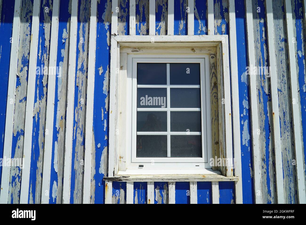 Small closed window of a blue weathered house Stock Photo - Alamy