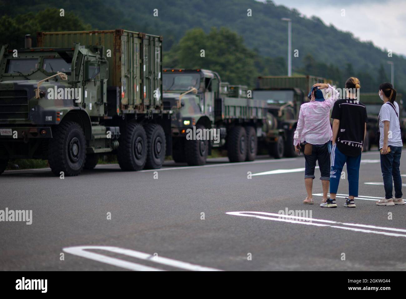 Japanese locals point at a 7-ton truck during a convoy at a rest stop in Japan, July 10, 2021. U.S. Marines with MWSS-171 began Eagle Wrath 21, a two-week exercise at CATC Camp Fuji to maintain a high level of proficiency and combat readiness. Stock Photo
