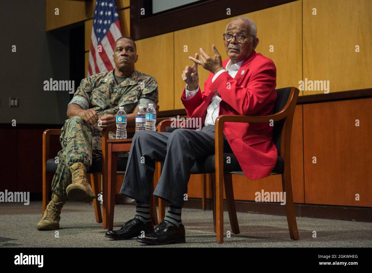 Documented Original Tuskegee Airman, U.S. Army Air Forces Sgt. Thomas Newton (right) relates his experiences serving in the 99th Fighter Squadron from 1946-1949, while host U.S. Marines Lt. Col. Karl Tinson (left) listens along with a packed audience of U.S. Central Command personnel in the Vince Tolbert Building, MacDill Air Force Base, July 9, 2021. Tuskegee Airmen were a famous group of African American pilots, bombers, and their support personnel who fought in World War II. Stock Photo