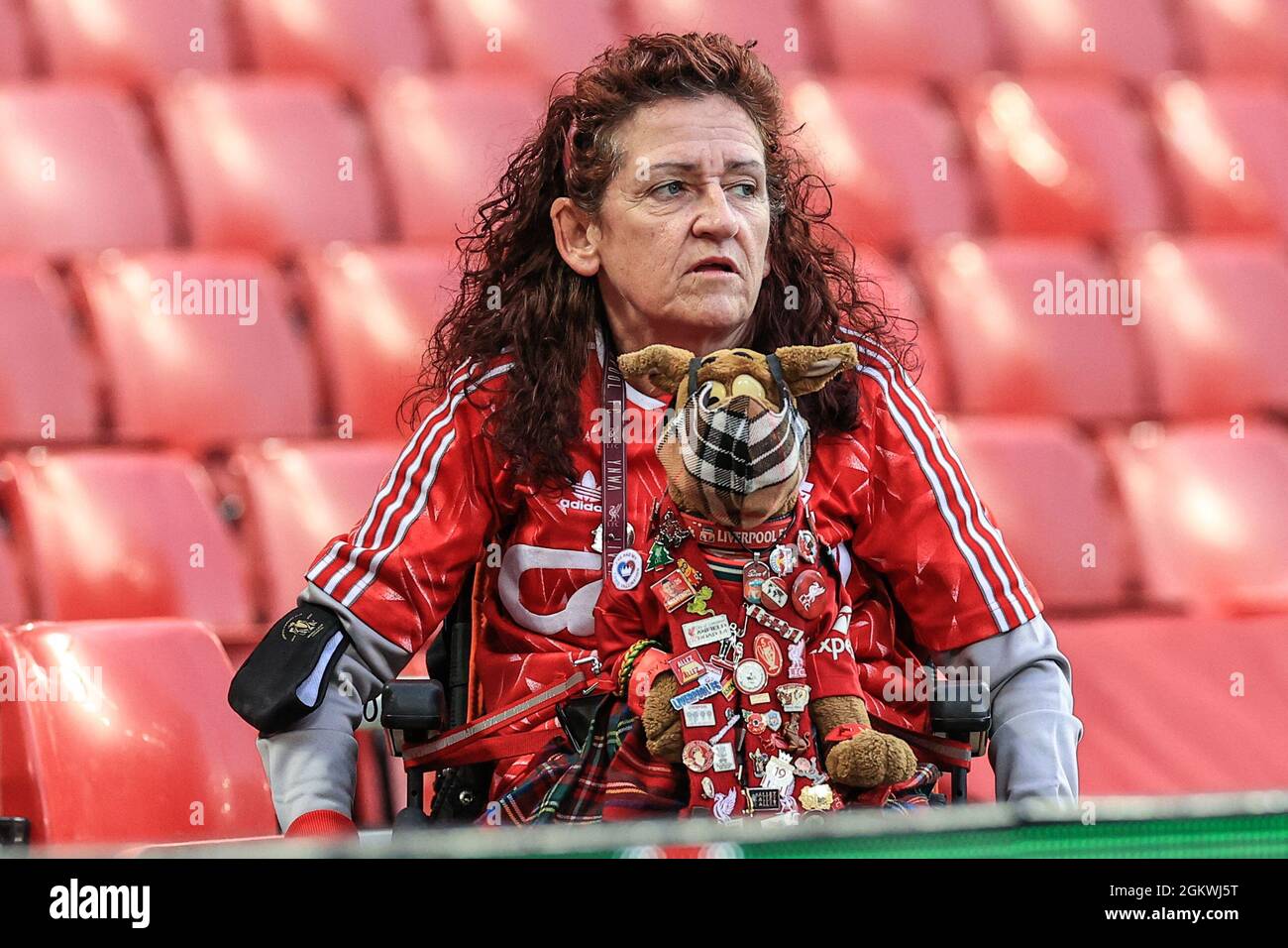 A Liverpool fan with her dog mascot covered with Liverpool pin badges