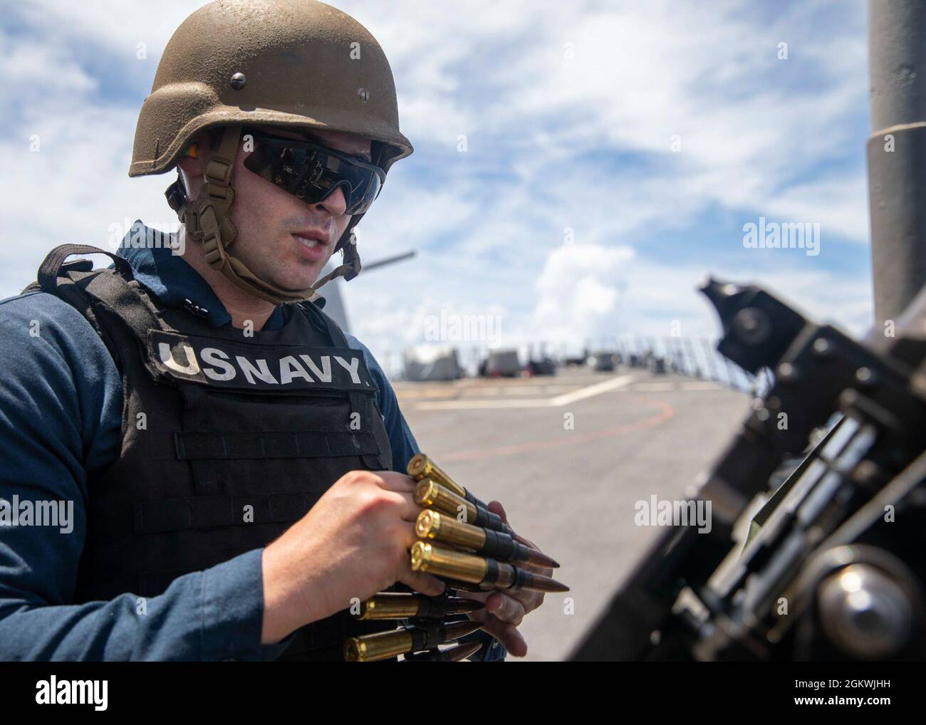 EAST CHINA SEA (July 10, 2021) Retail Specialist 3rd Class Christian Shields, from Stuart, Fla., reloads a .50 cal. machine gun during a crew-serve weapon familiarization aboard Arleigh Burke-class guided-missile destroyer USS John S. McCain (DDG 56). McCain is assigned to Task Force 71/Destroyer Squadron (DESRON) 15, the Navy’s largest DESRON and the U.S. 7th Fleet’s principal surface force. Stock Photo
