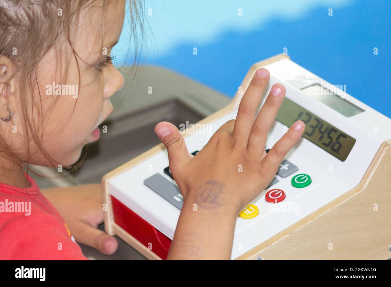Caucasian little girl of five years old playing with cashbox inside Stock Photo