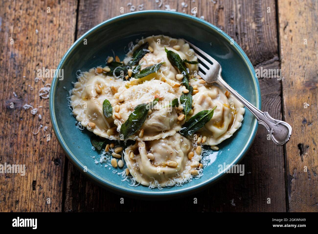 Home made pumpkin ravioli with crispy sage leaves and pinenuts Stock Photo