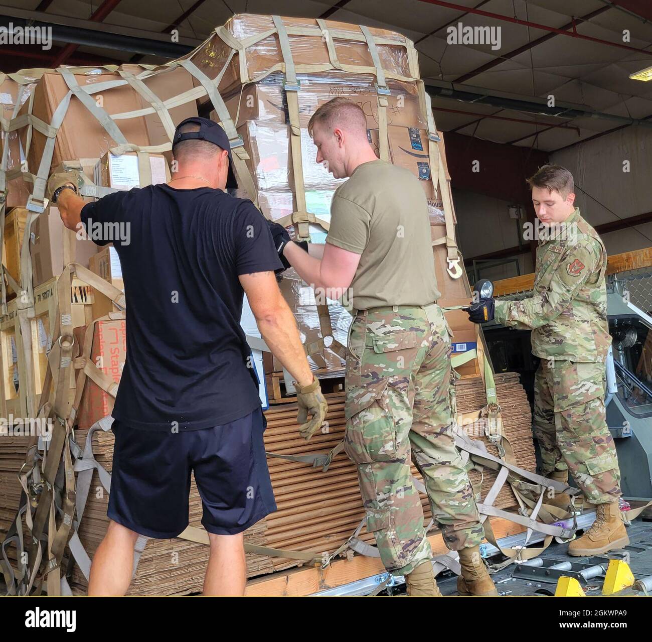 Mr. Daniel Guthrie, Polar Field Services cargo supervisor, works with Senior Airman Ian Chisholm (left) and Airman 1st Class Trevor Cornelius to secure a pallet of cargo at Stratton Air National Guard Base, Scotia, N.Y.  at Stratton Air National Guard Base, Scotia, N.Y.  The Air Force Reserve Airmen from the 87th Aerial Port Squadron are being trained by air transportation specialists assigned to the 109th Airlift Wing and will be working there for sixty days. Stock Photo