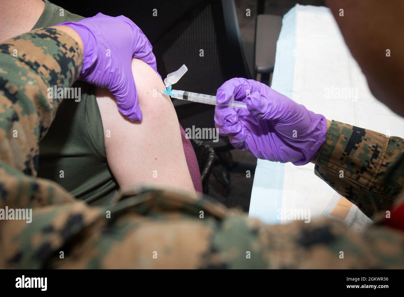 A U.S. Marine with Marine Rotational Force - Darwin, receives a dose of the COVID-19 vaccine at Larrakeyah Barracks, Darwin, NT, Australia, July 12, 2021. COVID-19 and influenza vaccines were transported to Larrakeyah and Robertson Barracks medical facilities to vaccinate U.S. service members in Australia’s Top End. The Marines and Sailors of MRF-D 21.2 successfully adhered to all COVID-19 mitigation procedures required by the Australian and U.S. governments to travel to the Northern Territory and now fall under protocols set by the local government. Stock Photo