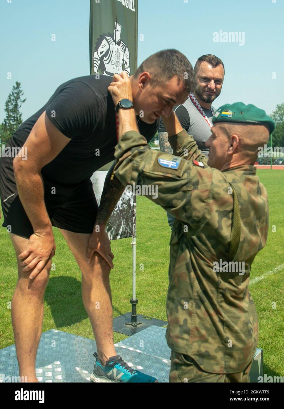 Polish Land Forces, 15th Mechanized Brigade Commander, Brig. Gen. Bogdan Rycerski, presents the javelin first place medal to British Army Lcpl. Peter Arnold at Stadion Miejski MOSIR in Giżycko, Poland July 13, 2021. Battle Group Poland had 40 competitors representing the U.S. Army, British Army and Romanian Land Forces compete in the track and field event, which included 100 meter, 400 meter, 800 meter and 4 X 400 meter races as well as, javelin throw, shot put, and long jump competitions. The inaugral multinational track and field event was held to celebrate Polish Land Forces 15th Mechanized Stock Photo