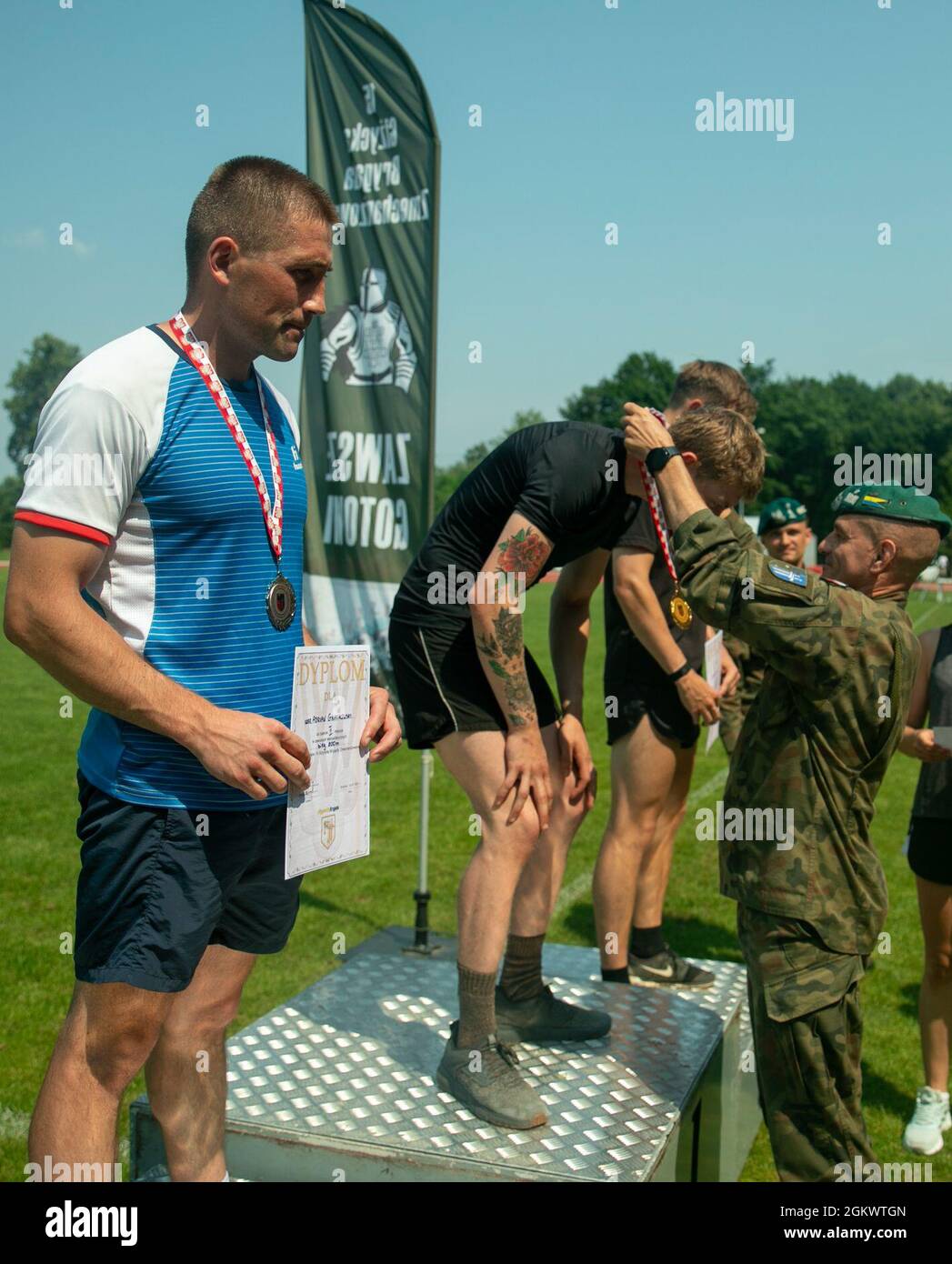 Brig. Gen. Bogdan Rycerski, Polish Land Forces, 15th Mechanized Brigade commander, presents the 800 meter race first place medal to British Army Pvt. Clyde Brayce at Stadion Miejski MOSIR in Giżycko, Poland July 13, 2021. Battle Group Poland had 40 competitors representing the U.S. Army, British Army and Romanian Land Forces compete in the track and field event, which included 100 meter, 400 meter, 800 meter and 4 X 400 meter races as well as, javelin throw, shot put, and long jump competitions. The inaugral multinational track and field event was held to celebrate Polish Land Forces 15th Mech Stock Photo