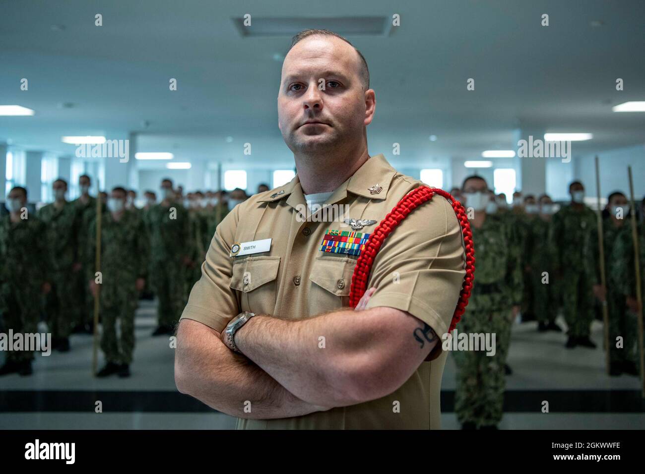 Aviation Boatswain’s Mate (Handling) 1st Class Benjamin Smith, a recruit division commander, poses for a portrait photo in front of his division at Recruit Training Command. More than 40,000 recruits train annually at the Navy's only boot camp. Stock Photo