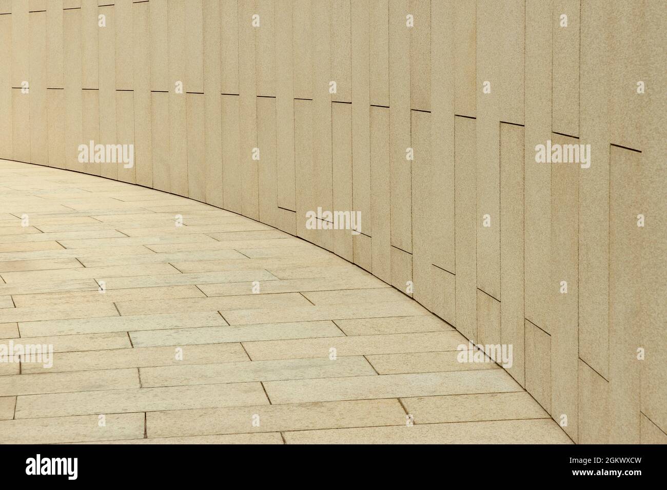 Fragment of footpath and wall paved with granite slabs Stock Photo