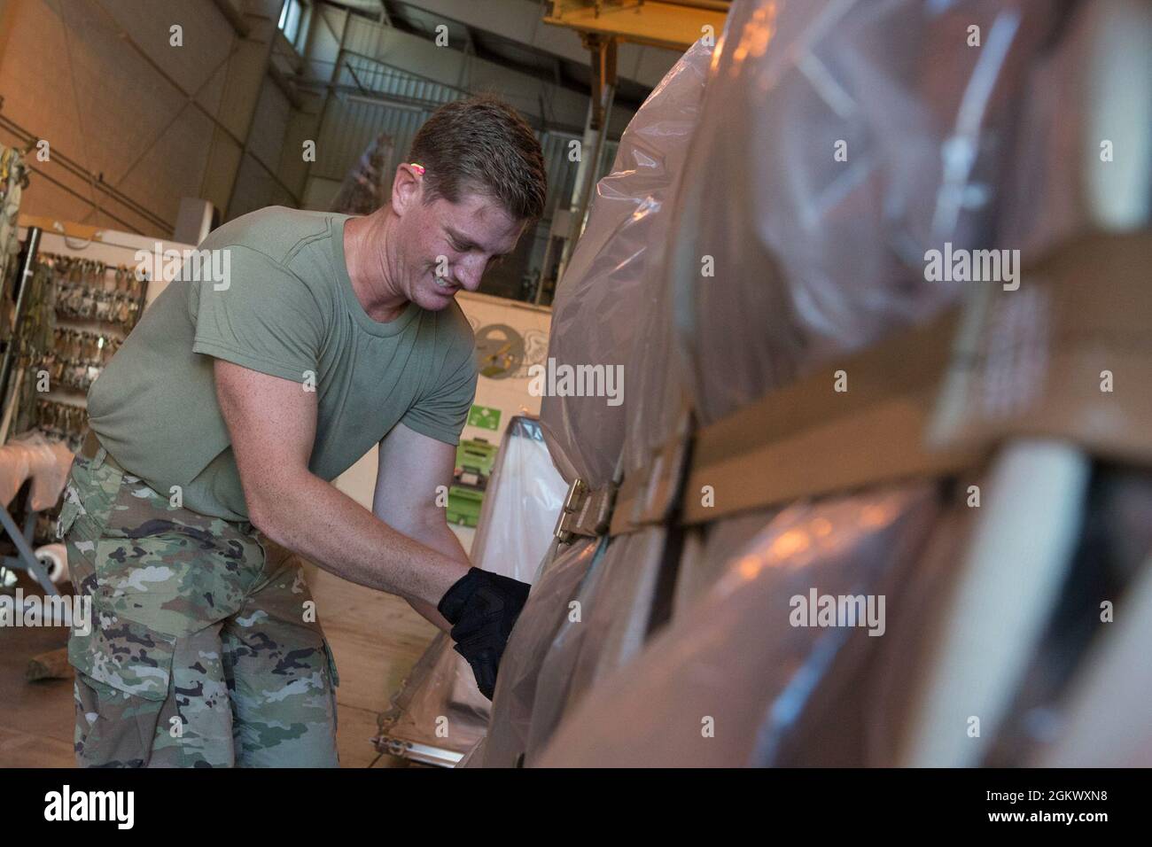 U.S. Air Force Senior Airman Alec Moser, an aerial transportation specialist with the 123rd Airlift Wing, Kentucky National Guard, secures cargo onto a pallet during a pallet building exercise at the 167th Airlift Wing, Martinsburg, West Virginia, Jul. 13, 2021. The 167th hosted members from the 123rd for a small air terminal training in preparation for their upcoming deployment. Stock Photo