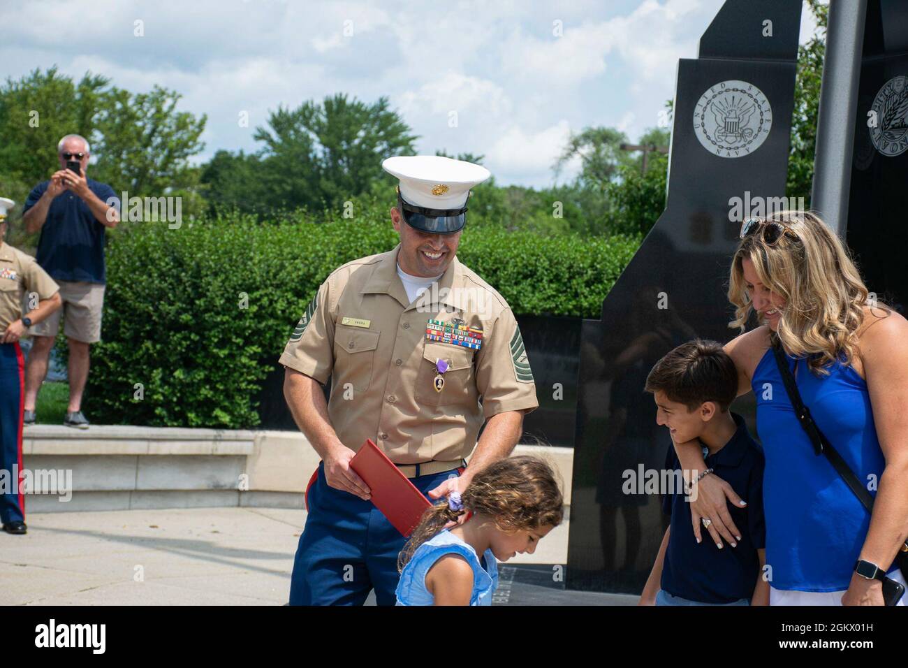 U.S. Marine Master Sgt. Dominic Freda, an assistant recruiter instructor, with Recruiting Station Cleveland shares a moment with his family during his purple heart ceremony at Veteran’s Memorial Plaza in Livonia, Michigan, July 14, 2021. Freda was serving as weapons platoon sergeant, Company I, 3rd Battalion, 6th Marines, Regimental Combat Team 7, 1st Marine Division, and received wounds in action during Operation Enduring Freedom, May 15, 2010. Stock Photo