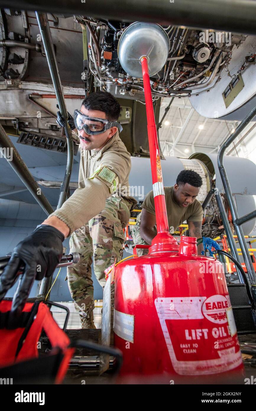 U.S. Air Force Staff Sgt. Douglas Rivera, left, and Senior Airman Daquiel Duncan, both 105th Maintenance Squadron aerospace propulsion specialists, Stewart Air National Guard Base, New York, change the oil on a C-17 Globemaster III engine July 14, 2021, at Travis Air Force Base, California. Each C-17 engine is capable of generating 40,440 pounds of thrust and includes thrust reversers that direct the flow of air upward and forward to avoid ingestion of dust and debris. Stock Photo