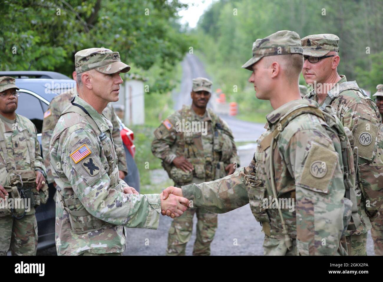 Spc. Ian Stewart, a combat engineer assigned to Bravo Company of the New York Army National Guard's 152nd Brigade Engineer Battalion, receives a challenge coin from Col. Sean Flynn, commander of the 27th Infantry Brigade Combat Team at Fort Drum, New York on July 14, 2021. Stewart, who is a vehicle driver, was recognized for outstanding performance while his unit conducted demolition training. Stock Photo