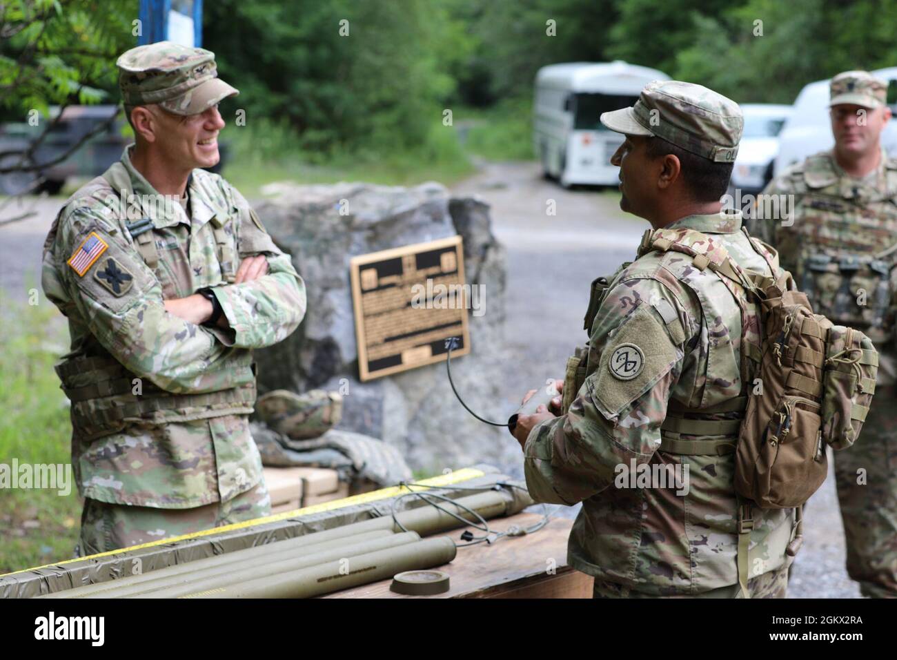 Col. Sean Flynn, commander of the 27th Infantry Brigade Combat Team, speaks with Staff Sgt. Manuel Olivo, a combat engineer assigned to the New York Army National Guard's Bravo Company, 152nd Brigade Engineer Battalion, while he assembles an improvised claymore mine at Fort Drum, New York on July 14, 2021.As part of the company's annual training, combat and horizontal construction engineers practiced emplacing C4 explosives, shaping and cratering charges, bangalore torpedoes, and explosively formed projectiles, as well as using improvisation techniques to broaden their capabilities. Stock Photo