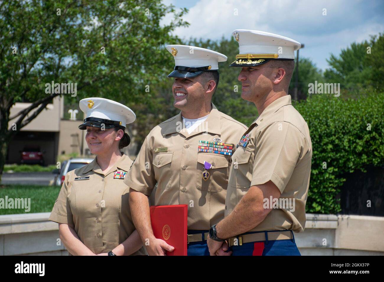 U.S. Marine Master Sgt. Dominic Freda, center, an assistant recruiter instructor with Recruiting Station (RS) Cleveland, Maj. Brian Hubert, right, the commanding officer of RS Cleveland and Sgt. Maj. Rachel Sienkiel, left, the sergeant major of RS Cleveland share a moment during his purple heart ceremony at Veteran’s Memorial Plaza in Livonia, Michigan, July 14, 2021. Freda was serving as weapons platoon sergeant, Company I, 3rd Battalion, 6th Marines, Regimental Combat Team 7, 1st Marine Division, and received wounds in action during Operation Enduring Freedom, May 15, 2010. Stock Photo