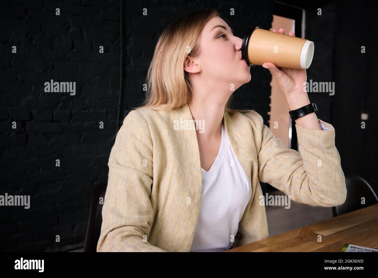 Woman drinks coffee from paper cup Stock Photo