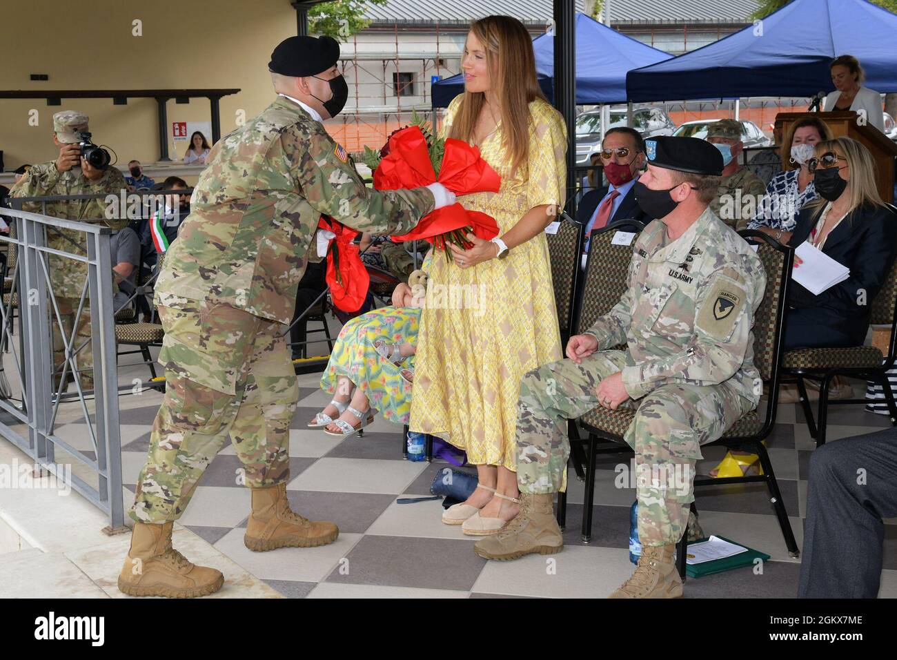 Mrs. Amanda Vogel, wife to Col. Daniel J. Vogel, outgoing commander of U.S. Army Garrison Italy, is awarded red flowers during change of command ceremony under Covid-19 prevention condition at Caserma Ederle, Vicenza, Italy July 16, 2021. Stock Photo