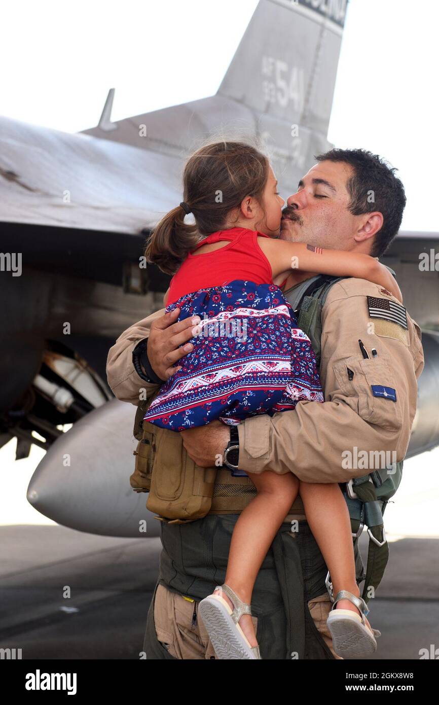 U.S. Air Force Maj. Joshua Rosecrans, a 157th Fighter Squadron pilot, greets his daughter at McEntire Joint National Guard Base, South Carolina, after returning from a deployment to Prince Sultan Air Base, Kingdom of Saudi Arabia, July 16, 2021. “Swamp Fox” Airmen from the South Carolina Air National Guard’s 169th Fighter Wing were deployed to PSAB for the past three months to project combat power and help bolster defensive capabilities against potential threats in the region. Stock Photo