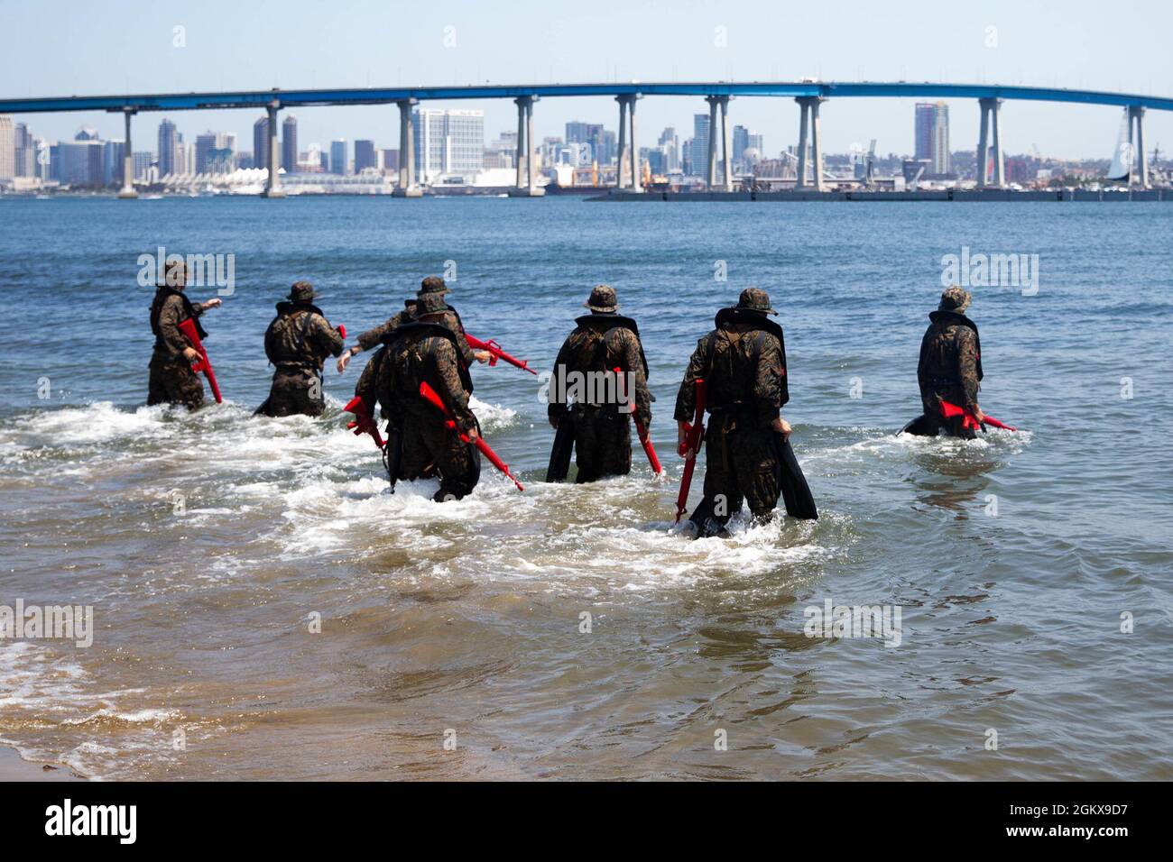 U.S. Marines with Co. C, 1st Battalion, 5th Marine Regiment, 1st Marine Division, make their way into the ocean during a Scout Swimmer Course on Naval Amphibious Base Coronado, California, July 17, 2021. The Marines learned the skills necessary to plan and execute swimmer reconnaissance for a small boat raid company in preparation for deployment. Stock Photo