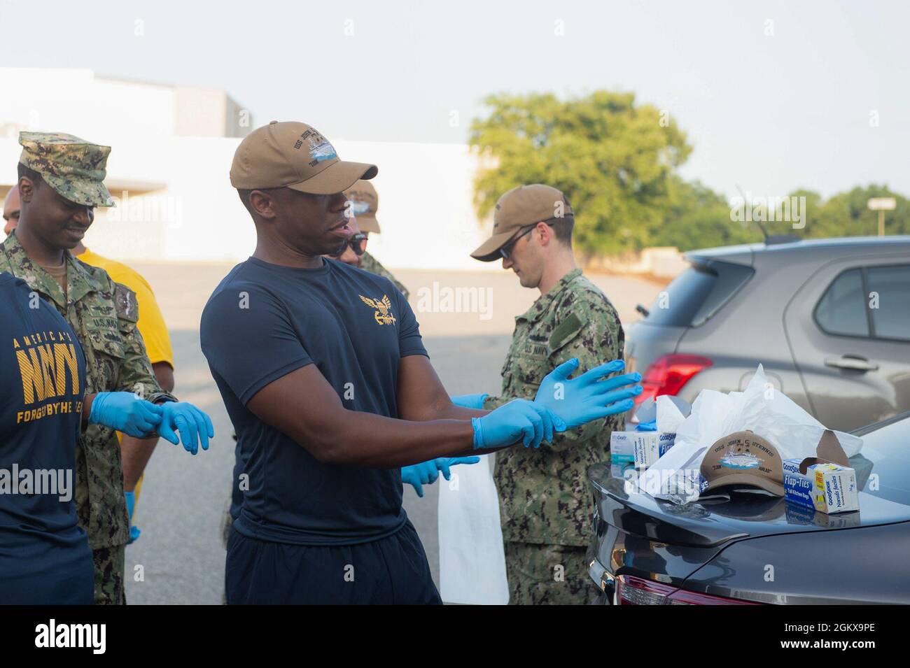 U.S. Navy Aviation Electronics Technician 1st Class Robert Fenwick, center, from Miami, assigned to the aircraft carrier USS John C. Stennis (CVN 74), participates in a first class petty officer association community relations event to pick up trash in the NetCenter parking lot, in Newport News, Virginia, July 16, 2021. John C. Stennis is in Newport News Shipyard working alongside NNS, NAVSEA and contractors conducting Refueling and Complex Overhaul as part of the mission to deliver the warship back in the fight, on time and on budget, to resume its duty of defending the United States. Stock Photo