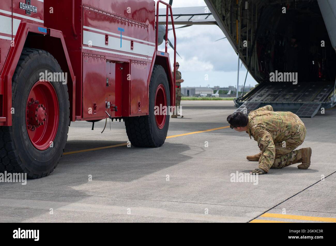 Staff Sgt. Alex Watson, 36th Airlift Squadron loadmaster from Yokota Air Base, Japan, inspects the underside of a P-19 firetruck, July 17, 2021, before loading onto a C-130J Super Hercules on Kadena Air Base, Japan in support of Pacific Iron 2021. Approximately 800 Airmen and 35 aircraft are participating in Pacific Air Forces’ dynamic force employment operation July 11 to Aug. 8, 2021, in Guam and Tinian to project forces into the U.S. Indo-Pacific Command’s area of responsibility in support of the 2018 National Defense Strategy, calling on the military to be a more lethal, adaptive and resil Stock Photo