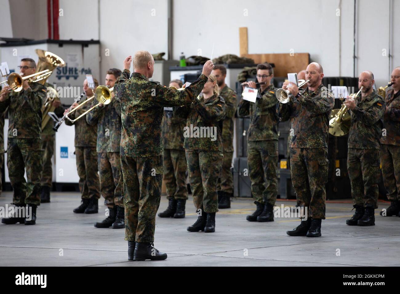 German Army soldiers, assigned to the Heeresmusikkorps Veitshöchheim, play the Army Song during a U.S. Army 1st Combat Aviation Brigade change of command ceremony at Illesheim Army Airfield, Germany, July 17, 2021. The 1st CAB is deployed to Europe in support of Atlantic Resolve, which maintains a rotational presence throughout Europe with U.S. forces living and training alongside allies daily, strengthening interoperability, improving communication, and enhancing the ability to anticipate, react, move and communicate as a cohesive team. Stock Photo