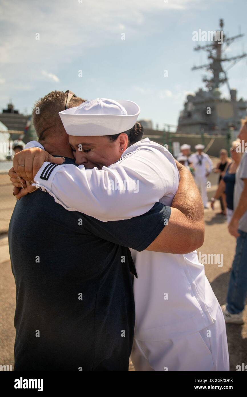 210718-N-GF955-1463  NAVAL STATION MAYPORT, Fla. (July 18, 2021) – Seaman Katie Helps, assigned to the Arleigh Burke-class guided-missile destroyer USS Donald Cook (DDG 75), embraces her father following the ship’s arrival to Naval Station Mayport, Florida. Donald Cook was a Forward Deployed Naval Forces-Europe (FDNF-E) destroyer at Naval Station Rota, Spain for seven years before a homeport shift to Naval Station Mayport. Stock Photo