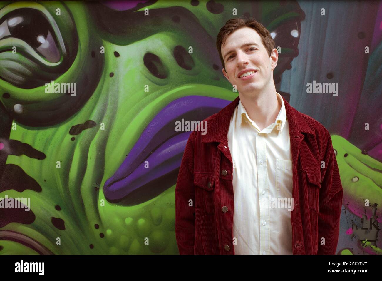 An attractive confident young man tilts his head back slightly and