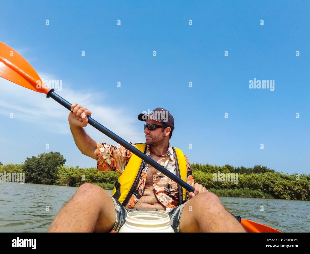 Young male rowing in a canoe in a river next to the beach in Estartit Stock Photo