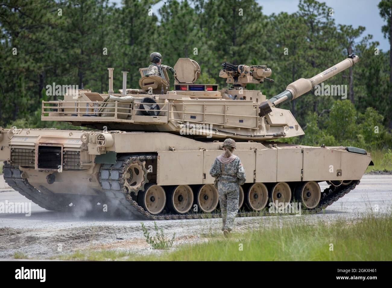 A U.S. Army Master Gunner Student, assigned to 3rd Squadron, 16th Calvary  Regiment, walks as a ground guide on the side of M1A2 SEP V2 Abrams Tank at  Ware Range, Fort Benning,