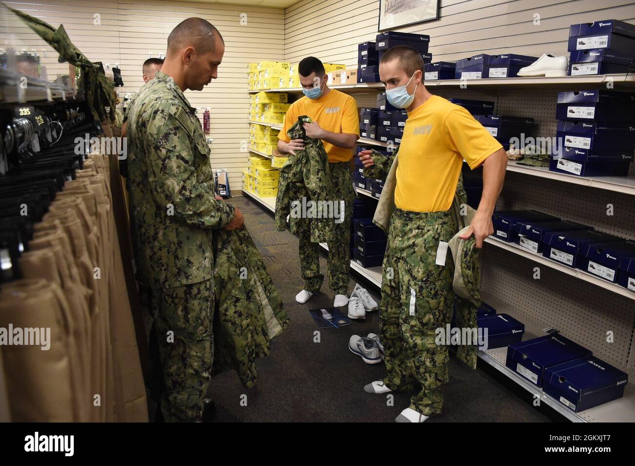 Senior Chief Gas Turbine Systems Technician Juan Rosa, a Recruit Division Commander (RDC) assigned to Officer Training Command Newport (OTCN), Rhode Island, observes an Officer Development School (ODS) class 21070 student test fit the Navy Working Uniform during an initial uniform issue, July 20. ODS provides staff corps officers and several restricted line designators with training necessary to prepare them to function in their role as newly commissioned Naval officers. Stock Photo