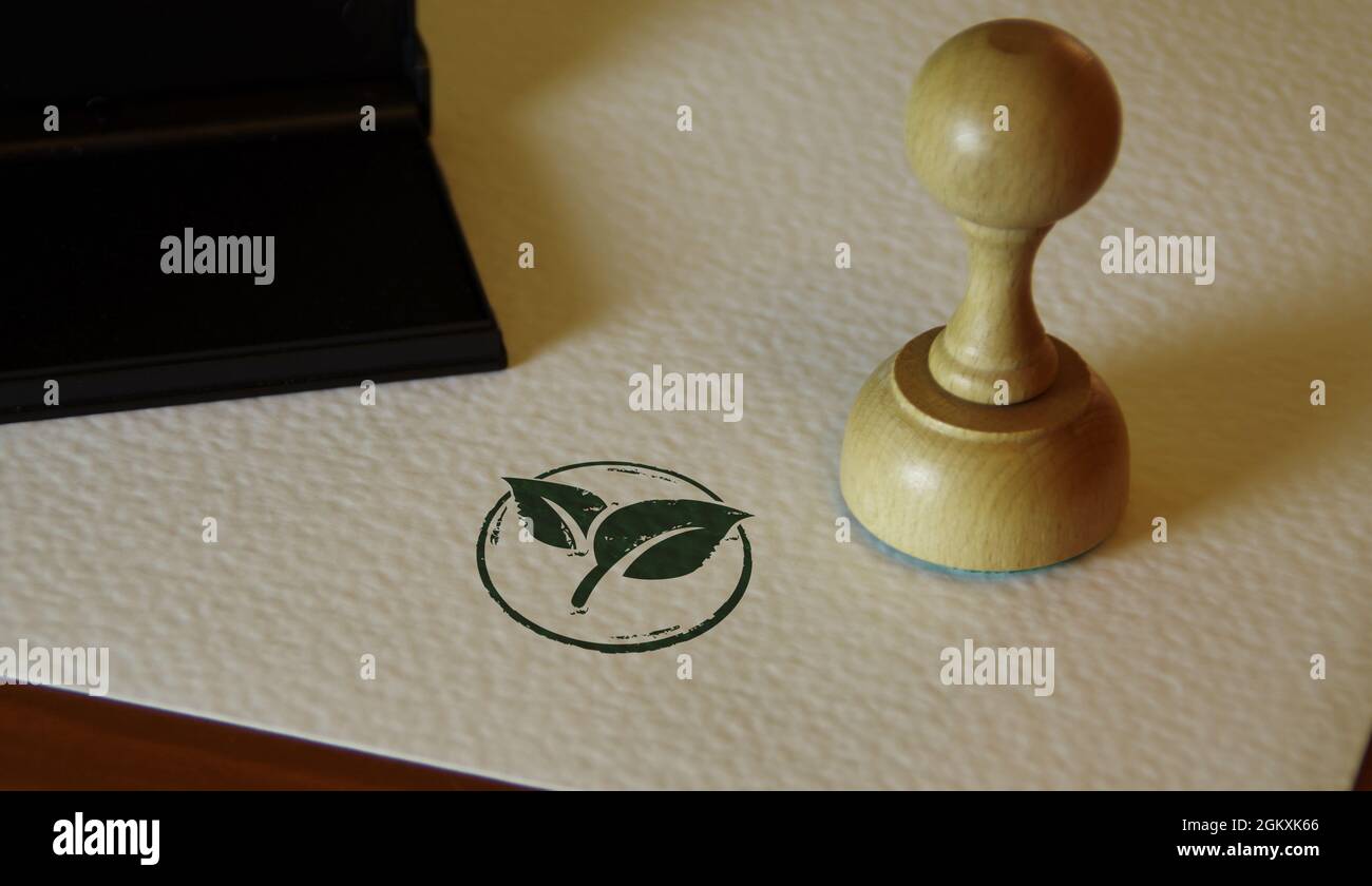 Green leaf eco friendly symbol stamp and stamping hand. Co2 neutral, ecology, environment, nature and climate concept. Stock Photo